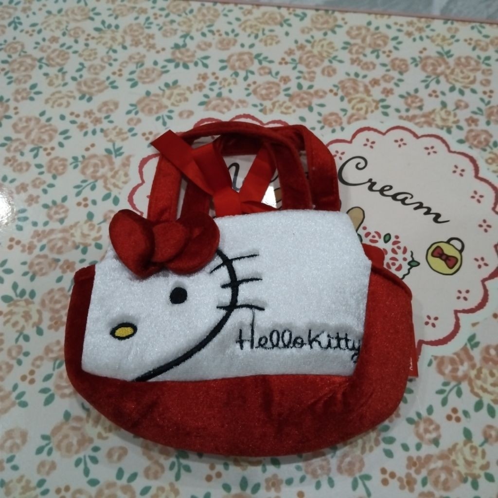 กระเป๋าถือใบเล็กที่เห็นในภาพคือกระเป๋ามินิพับผ้าหรือกระเป๋าใส่ของจุกจิกใบเล็กจาก Hello Kitty